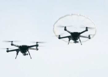 Drone avec parachute déployé dans le ciel.