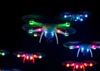 Drones lumineux illuminant le ciel nocturne.
