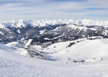 Montagne enneigée et tremplin de saut à ski.