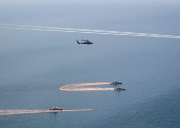 Hélicoptère militaire, deux patrouilleurs, bouées, fumée orange sur côte française.