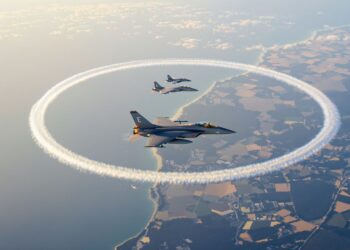 Deux Rafale survolent deux boucles de traînées au-dessus du littoral.