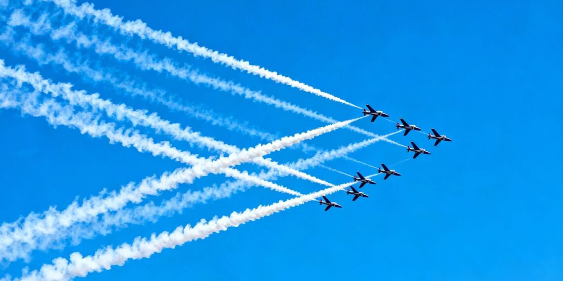 Manifestation aérienne à Nîmes avec des avions laissant des traînées.