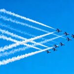 Manifestation aérienne à Nîmes avec des avions laissant des traînées.