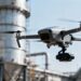 Drone inspectant une structure industrielle.