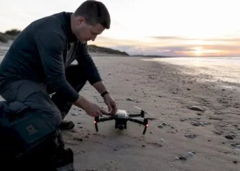 Un photographe installe son drone sur le toit d’un immeuble en ville.
