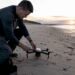 Un photographe installe son drone sur le toit d’un immeuble en ville.