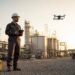 Un pilote de drone supervise les opérations sur un site industriel.
