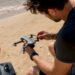Avant le décollage, le pilote inspecte minutieusement son drone léger pour s’assurer que tout fonctionne parfaitement.