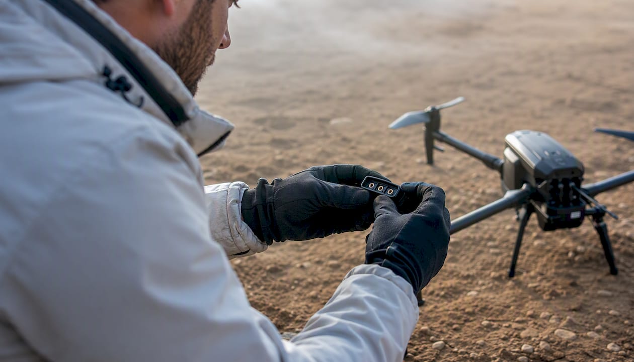 Un technicien vérifie le connecteur de la batterie du drone.