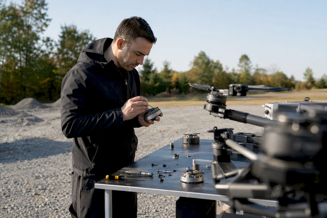 Des mains effectuent l'entretien minutieux d'un moteur de drone.