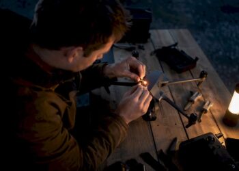 Pilote de drone fixant une lumière anti-collision au crépuscule