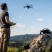 Pilote de drone maniant la télécommande avec le drone en vol