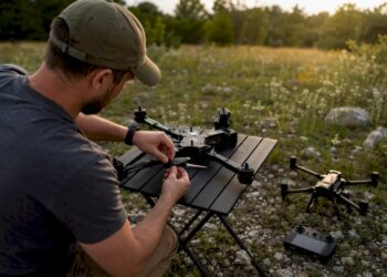 Télépilote en train d’assembler un drone en extérieur