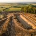 Drone survolant un chantier de terrassement, engins et talus en contrebas, avant un calcul de volume (illustration)