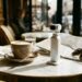 Caméra de poche à nacelle blanc perle posée sur une table de café, à côté d'un plan de ville (illustration)