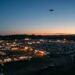 Drone relié au sol par un câble, en surveillance au-dessus d’un grand site événementiel au crépuscule