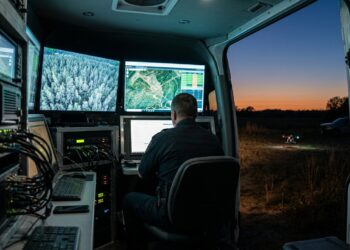Poste de commandement mobile au crépuscule recevant la vidéo en direct d’un drone de secours