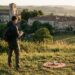 Pilote en repérage avant une prise de vue aérienne au drone face à un village