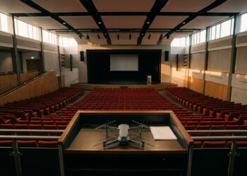 Drone posé sur le pupitre d'un auditorium vide, illustration de la Roma Drone Conference